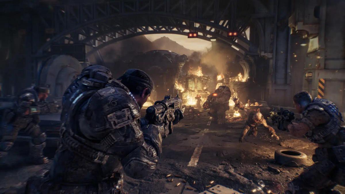 Soldați în armuri grele luptându-se cu monștri într-un mediu urban ruinat din Gears of War: E-Day.